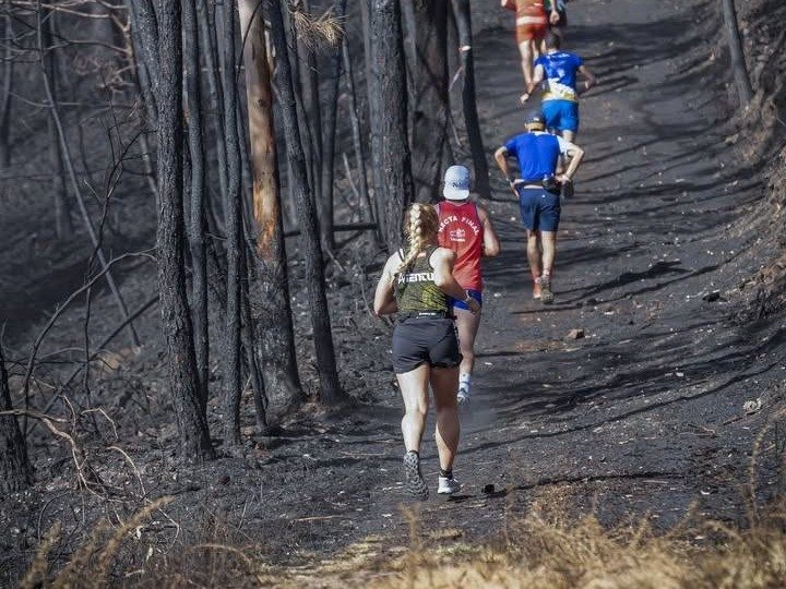 Corredores atravesando el monte quemado tras el incendio de 2023